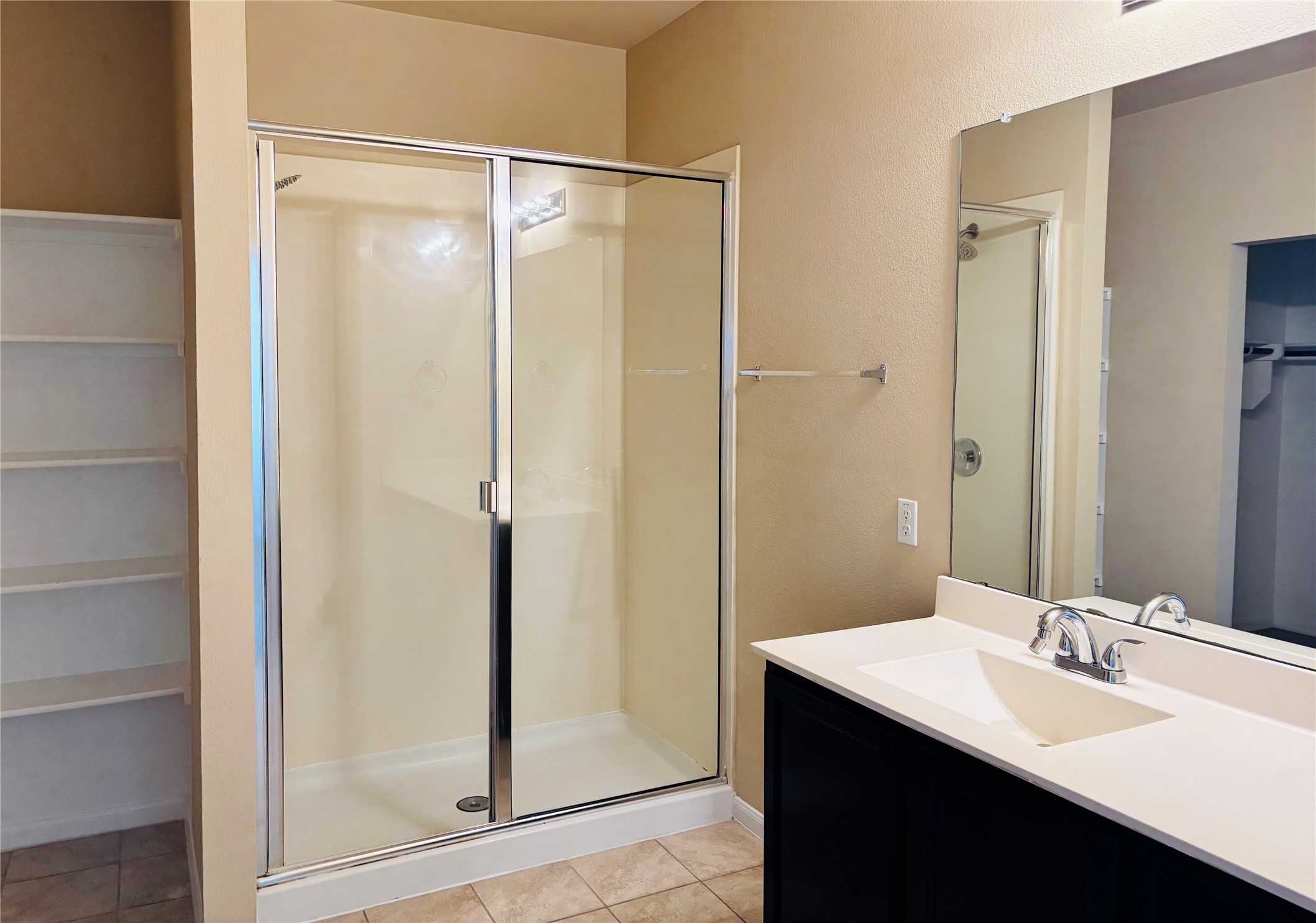 1602 Atlas Road Cedar Park, TX 78613 - Photo 8 of 13 A sleek vanity with ample counter space complements the glass-enclosed shower, creating a fresh and modern bathroom retreat.