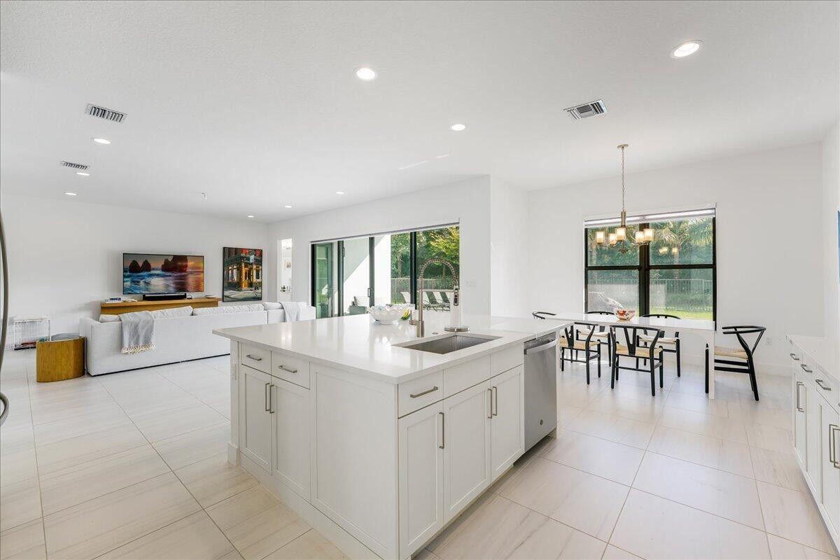 17496 Sparkling River Road Boca Raton, FL 33496 - Photo 3 of 36 a large white kitchen with a large window