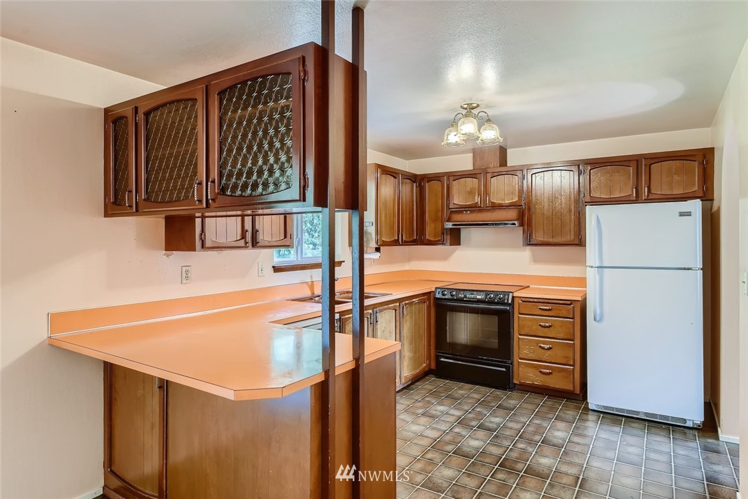 1823 224th Street Southwest Bothell, WA 98021 - Photo 17 of 27 a kitchen with stainless steel appliances granite countertop a refrigerator a stove and a sink with granite countertops