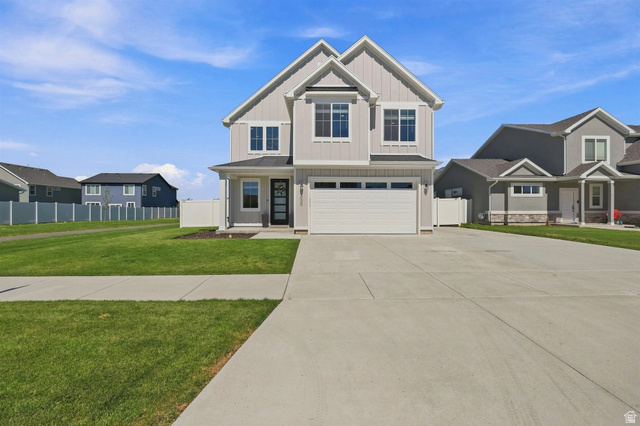 355 West 3085 South Logan, UT 84321 - Photo 2 of 40 Light gray vertical siding exterior with white trim, a covered entry, an attached garage, and a concrete driveway