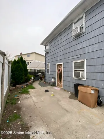 a view of a brick house with chairs in front of it