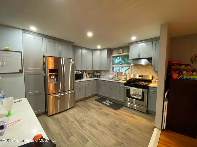 a kitchen with granite countertop a refrigerator and a stove top oven