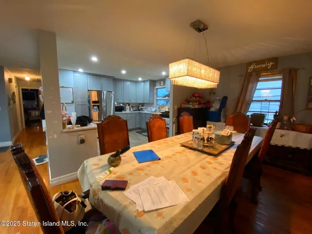 a living room with furniture a dining table and a chandelier