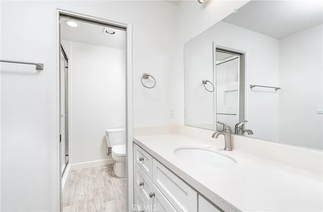 a bathroom with a sink a toilet and a mirror