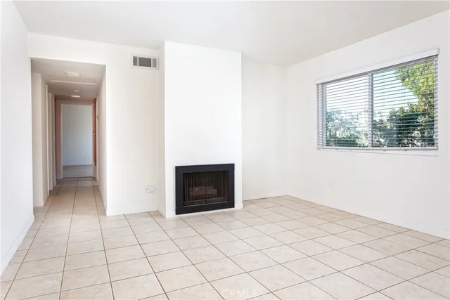 an empty room with windows and fireplace