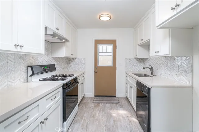 a kitchen with granite countertop a sink stove and refrigerator