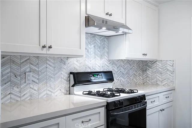 a white stove top oven sitting inside of a kitchen