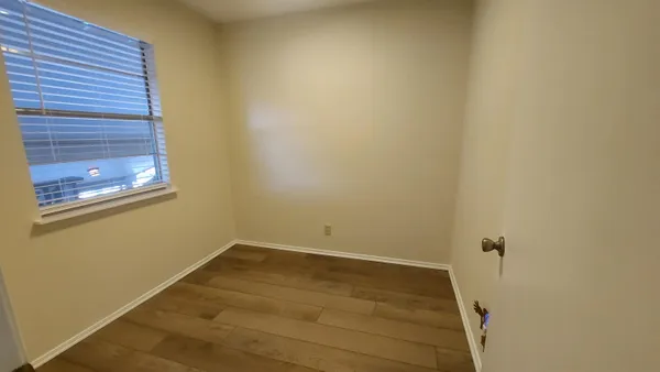 a view of a room with wooden floor and a window