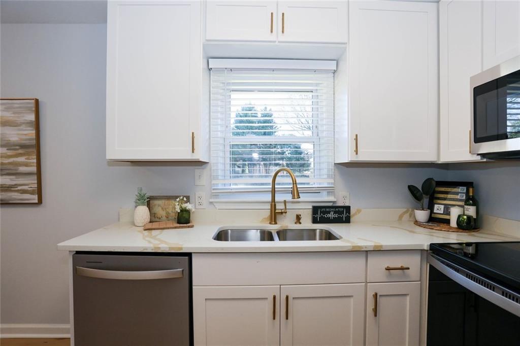 1745 Rockbridge Road Northwest Conyers, GA 30012 - Photo 11 of 46 a kitchen with stainless steel appliances granite countertop a sink a stove and a microwave