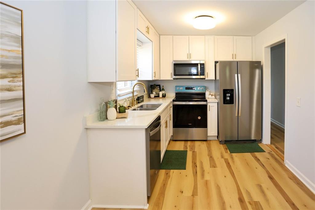 1745 Rockbridge Road Northwest Conyers, GA 30012 - Photo 8 of 46 a kitchen with a sink a counter top space stainless steel appliances and cabinets