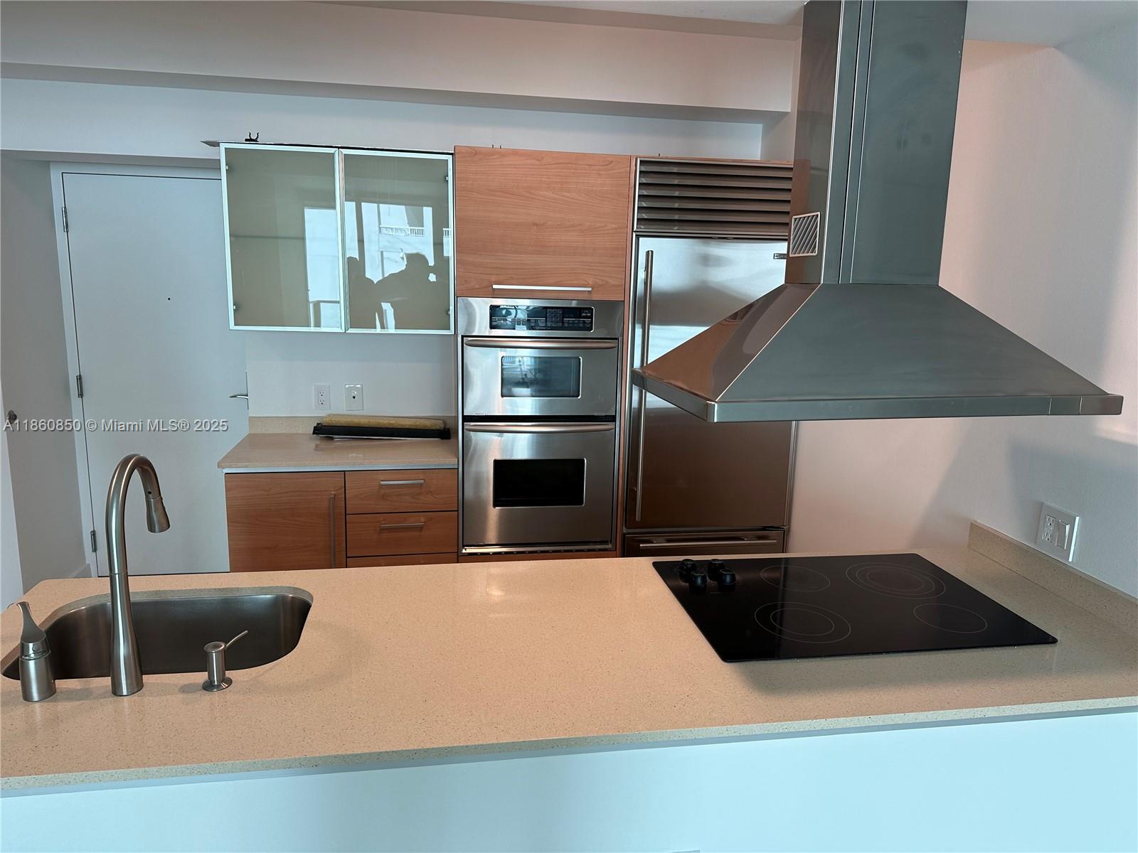 218 Southeast 14th Street, Unit 1508 Miami, FL 33131 - Photo 2 of 12 a kitchen with a sink and a stove top oven