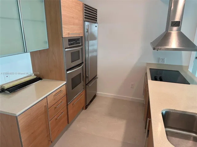 a kitchen with a refrigerator and a stove top oven
