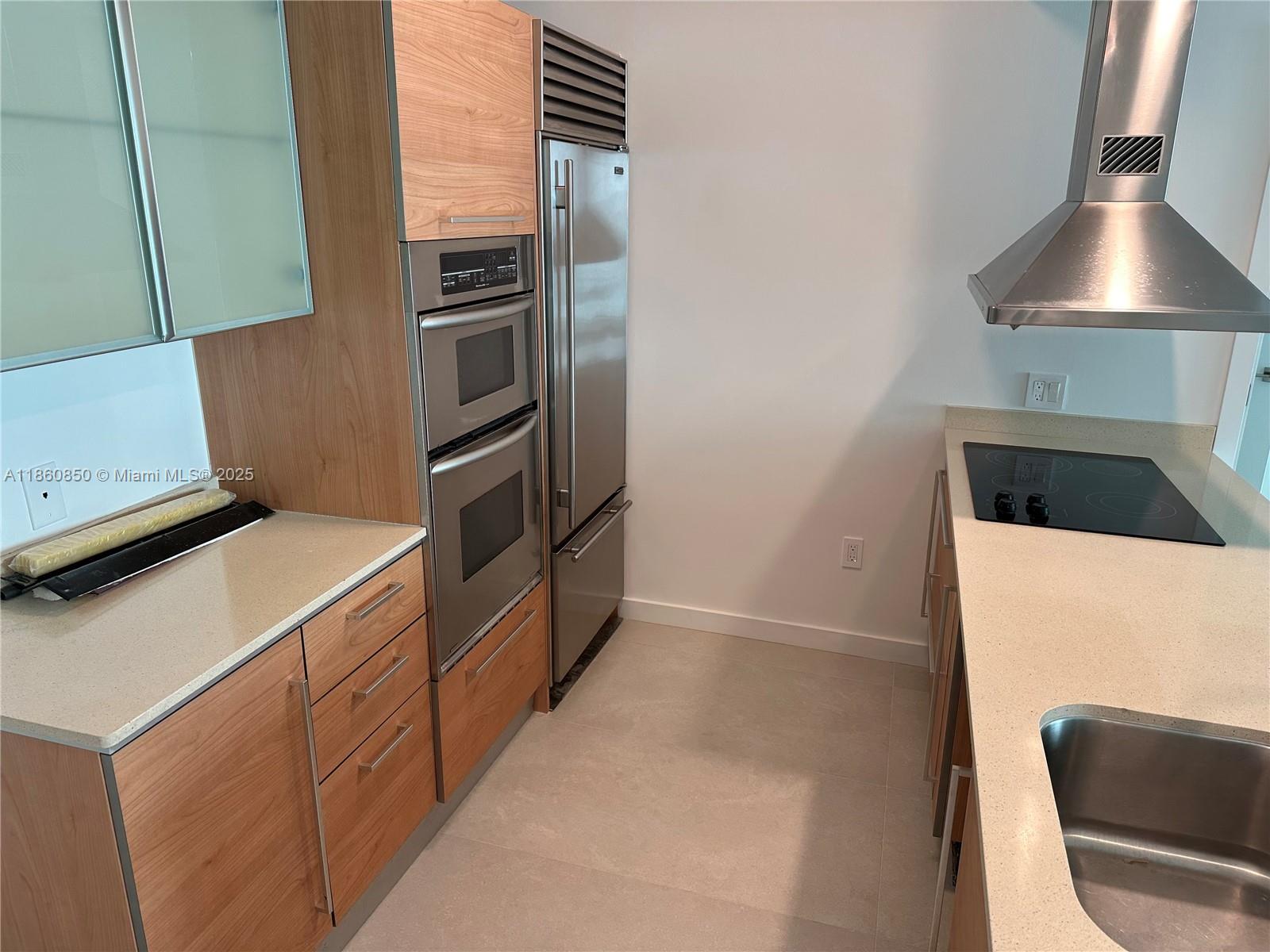 218 Southeast 14th Street, Unit 1508 Miami, FL 33131 - Photo 3 of 12 a kitchen with a refrigerator and a stove top oven