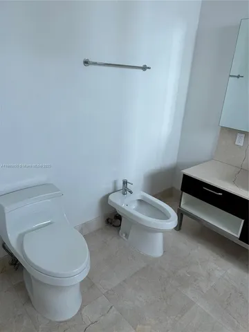 a white toilet sitting next to a white sink