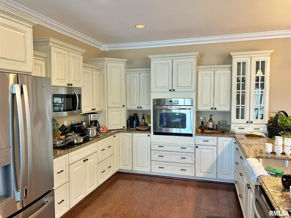 a kitchen with granite countertop white cabinets and stainless steel appliances