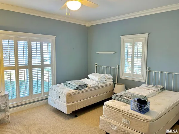 a bedroom with two beds and large window