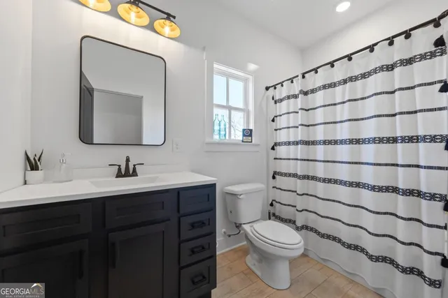 a kitchen with stainless steel appliances granite countertop a kitchen island hardwood floor sink stove dining table and chairs