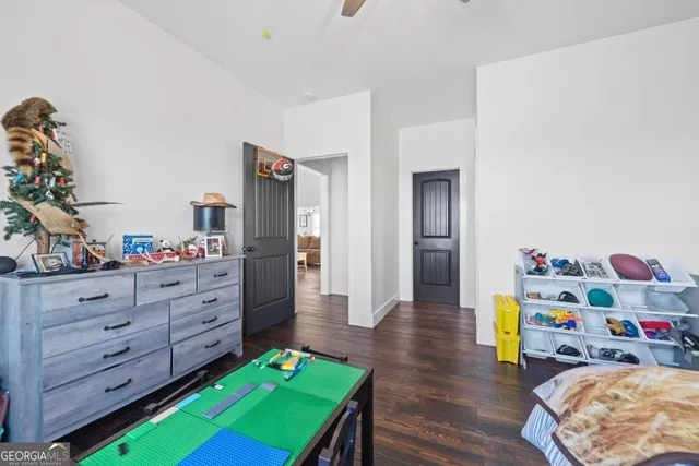 a open kitchen with stainless steel appliances granite countertop a sink dishwasher a stove a dining table and chairs with wooden floor