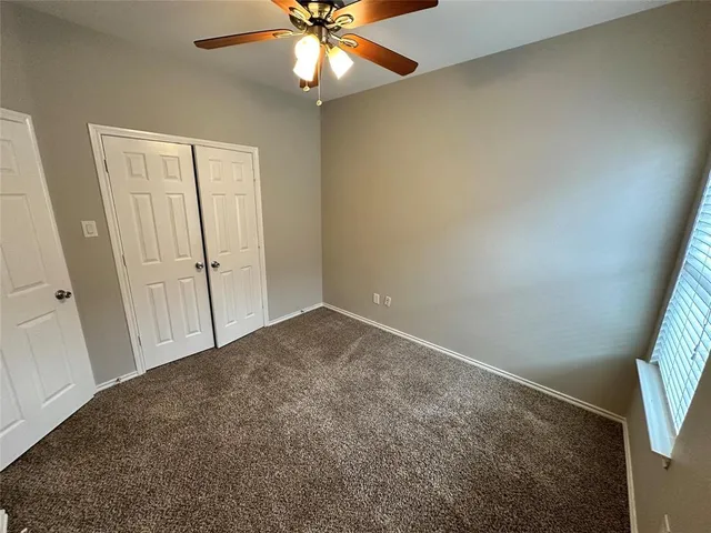 en empty room with windows and fan