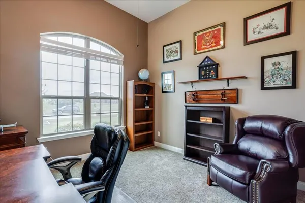 a view of a livingroom with workspace and a window