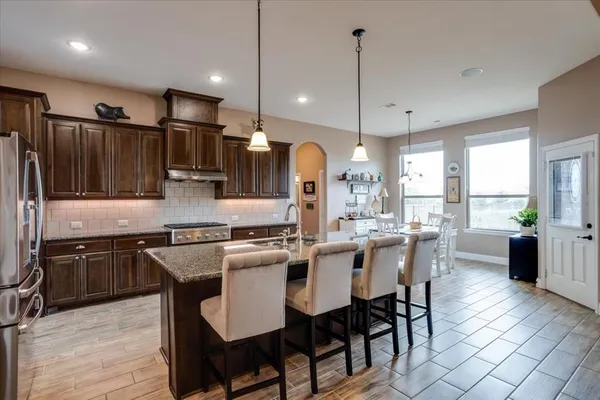a large kitchen with a table and chairs