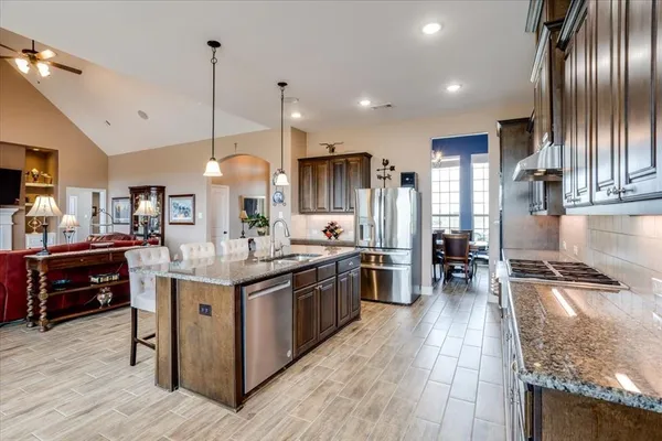 a kitchen with stainless steel appliances granite countertop a stove and a wooden floors