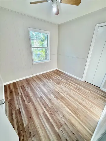 a view of empty room with window and ceiling fan
