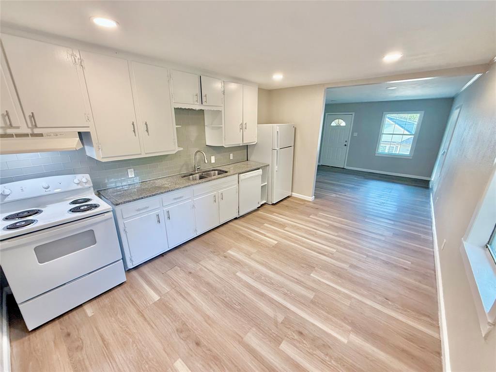 428 East Elm Street Denison, TX 75021 - Photo 4 of 18 a kitchen with stainless steel appliances granite countertop a sink a stove and a refrigerator
