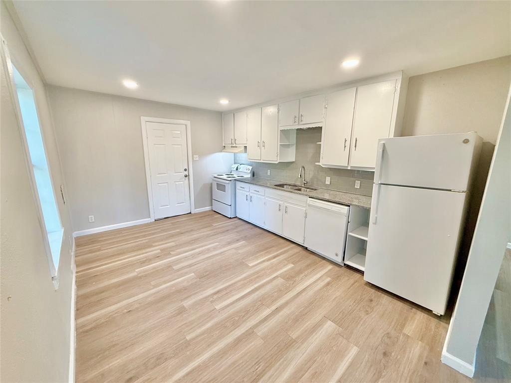 428 East Elm Street Denison, TX 75021 - Photo 6 of 18 a kitchen with white cabinets and white appliances