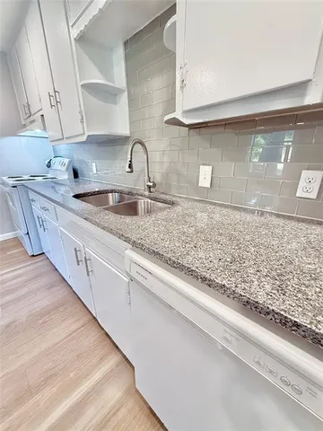 a kitchen with sink stove and cabinets