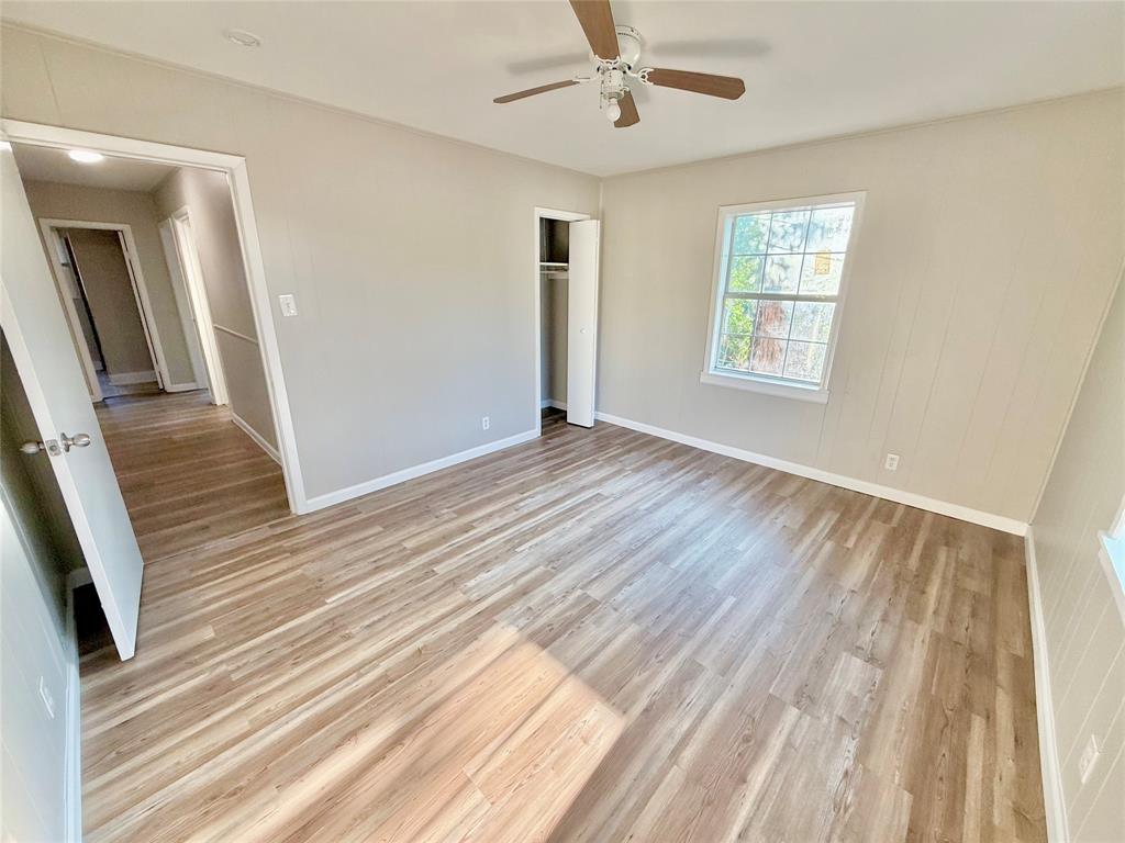 428 East Elm Street Denison, TX 75021 - Photo 8 of 18 a view of an empty room with wooden floor and a window