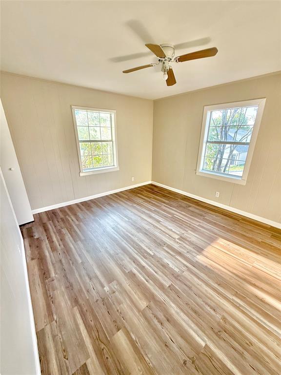 428 East Elm Street Denison, TX 75021 - Photo 9 of 18 a view of an empty room with wooden floor and a window