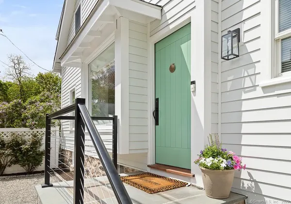 a front view of a house with outdoor seating and plants