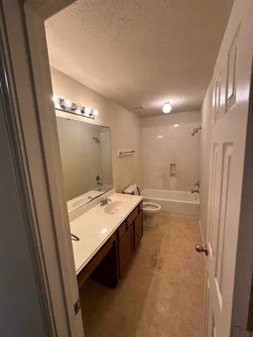 a bathroom with a tub sink and mirror