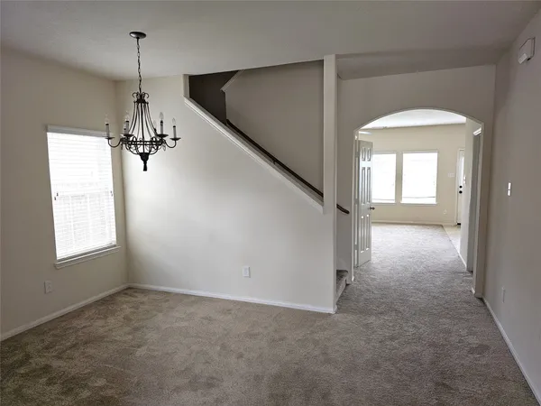 a view of a hallway with windows and chandelier