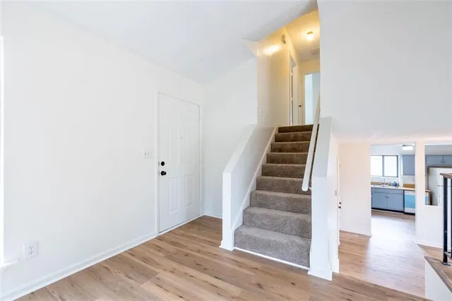 a view of an entryway with wooden floor and stairs