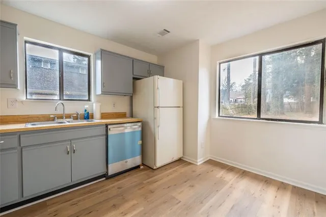 a kitchen with a refrigerator a sink and a large window