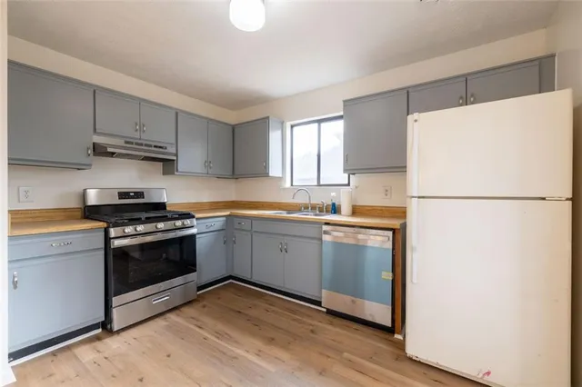 a kitchen with a refrigerator sink and cabinets