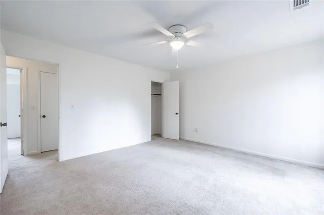 an empty room with a chandelier fan