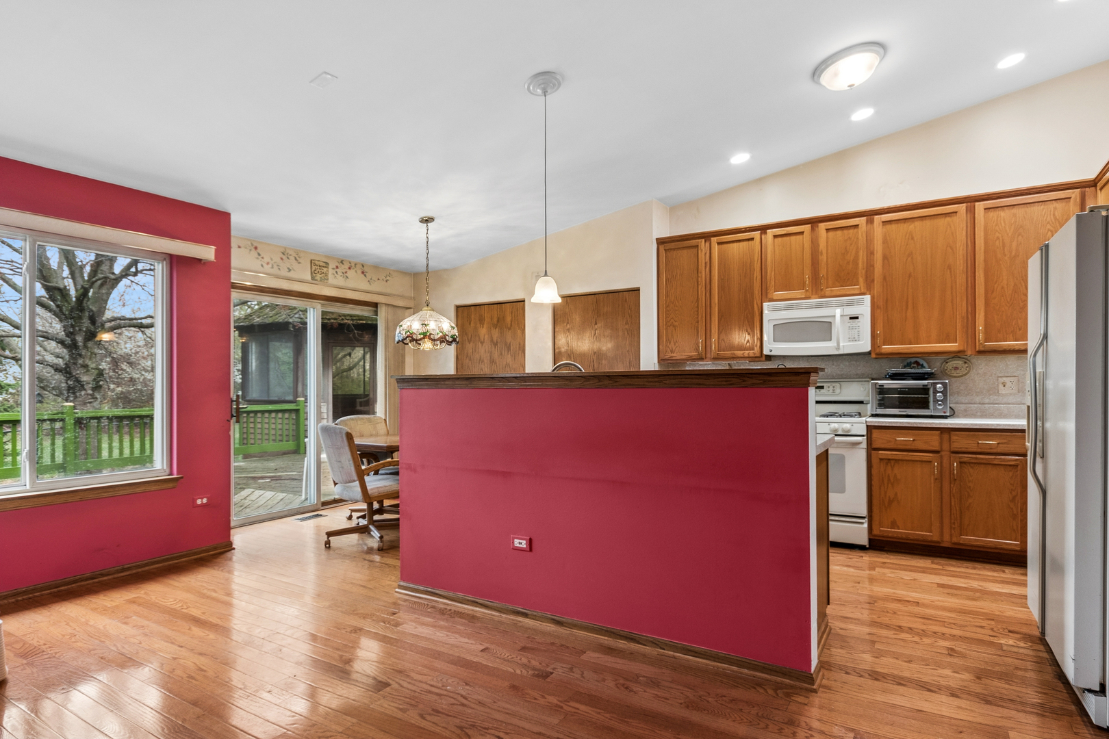 1921 Baldwin Way Bolingbrook, IL 60490 - Photo 12 of 20 a kitchen with stainless steel appliances kitchen island granite countertop a stove top oven a sink dishwasher a dining table and chairs with wooden floor