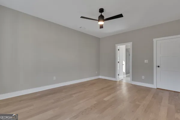 an empty room with windows and fan