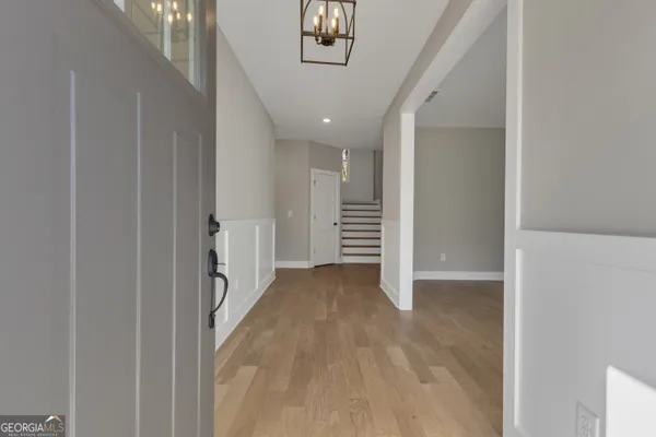 a view of an empty room with a window and chandelier