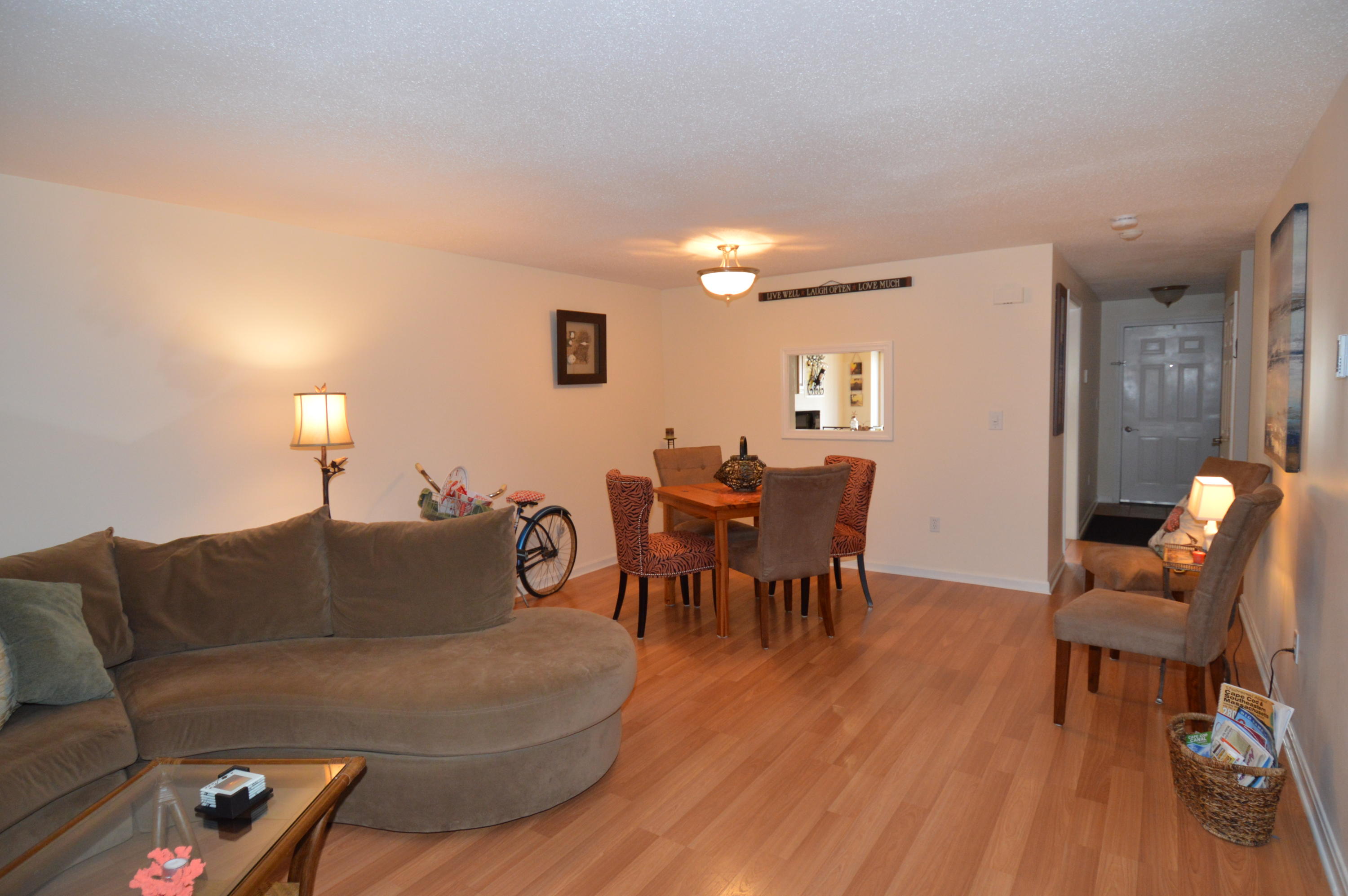 174 Lowell Road, Unit T30 Mashpee, MA 02649 - Photo 11 of 19 a living room with furniture a wooden floor and a dining table