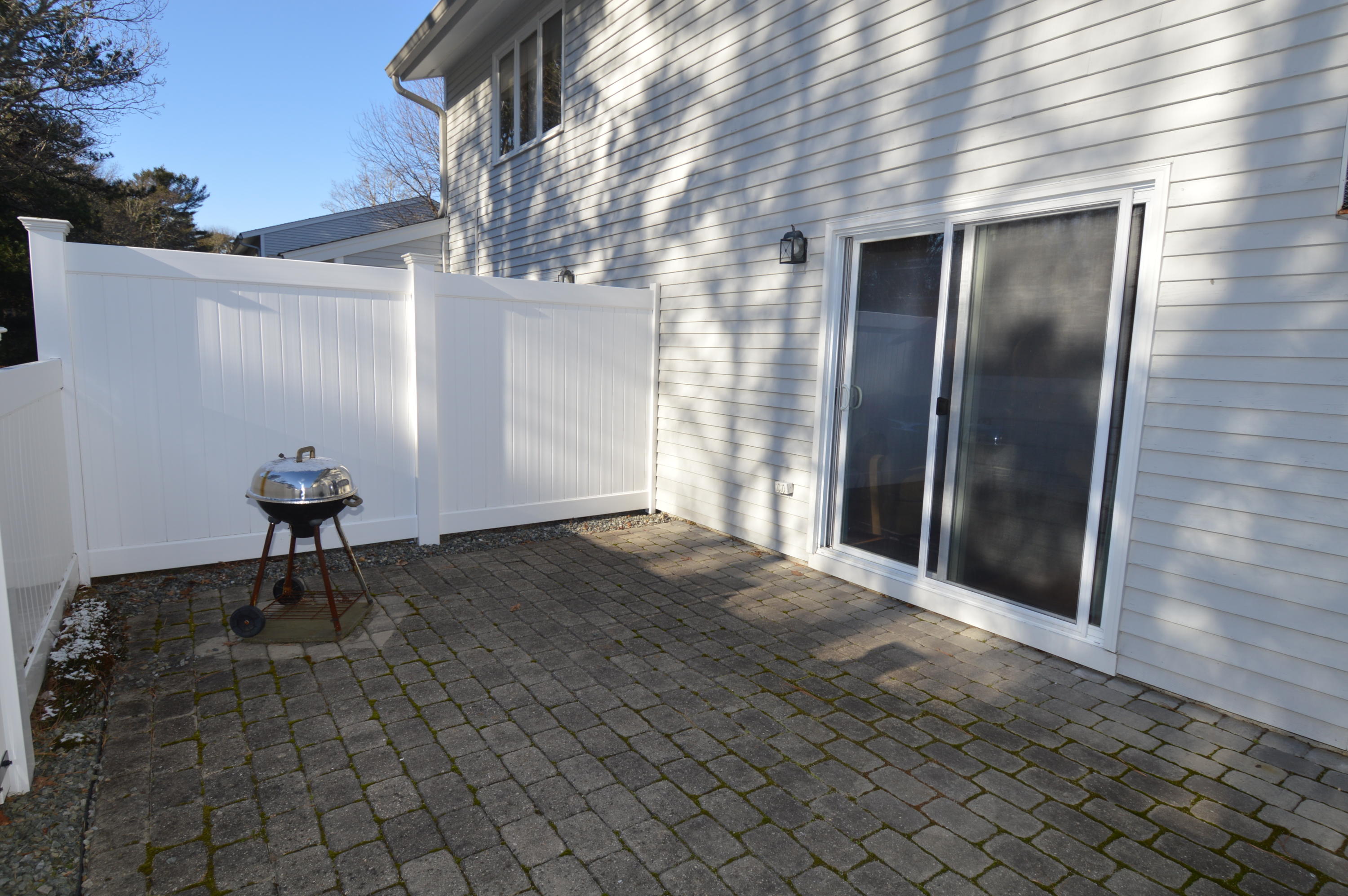 174 Lowell Road, Unit T30 Mashpee, MA 02649 - Photo 18 of 19 a view of backyard with a table and chair and wooden floor