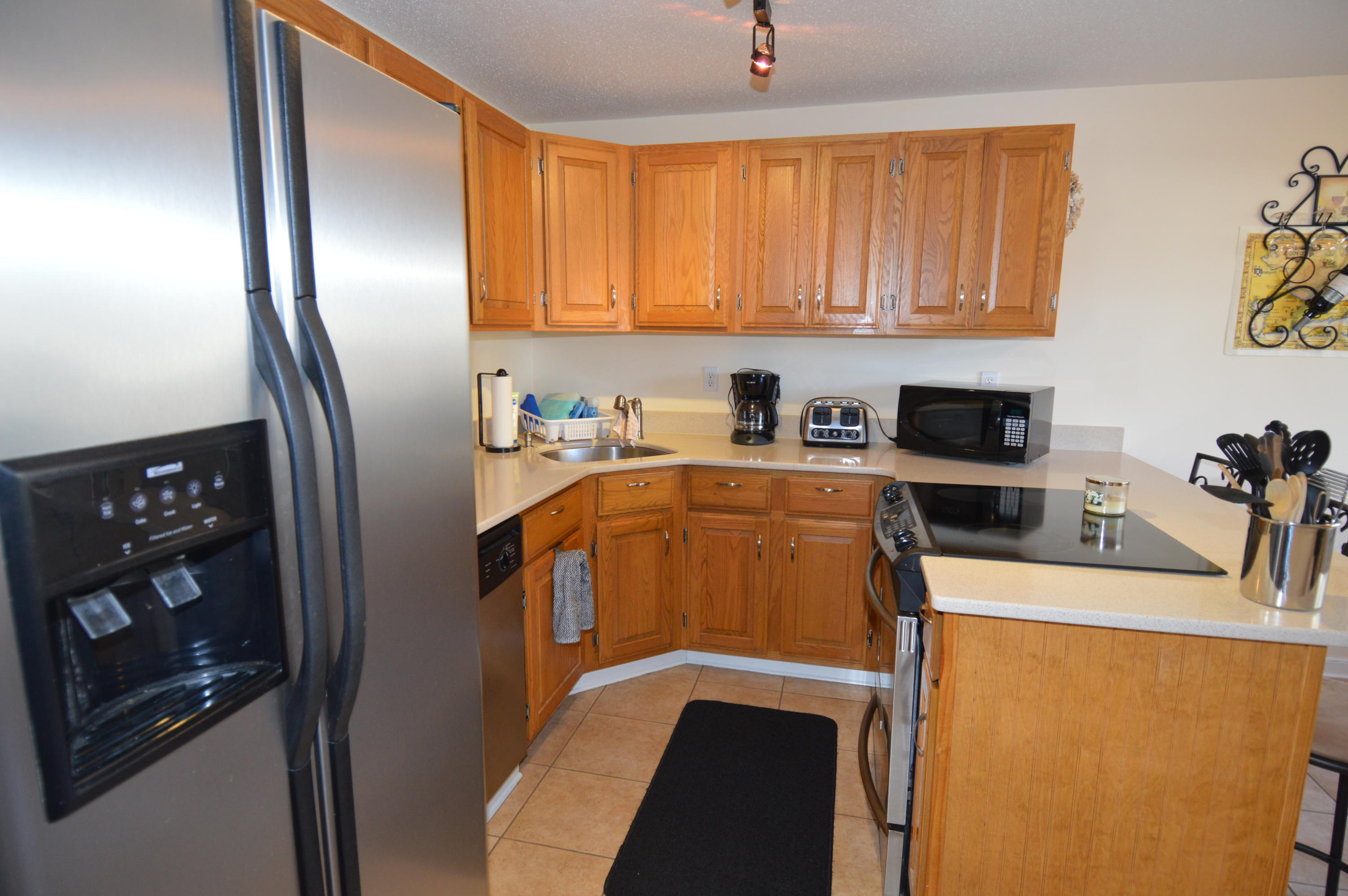 174 Lowell Road, Unit T30 Mashpee, MA 02649 - Photo 4 of 19 a kitchen with stainless steel appliances sink a refrigerator and cabinets