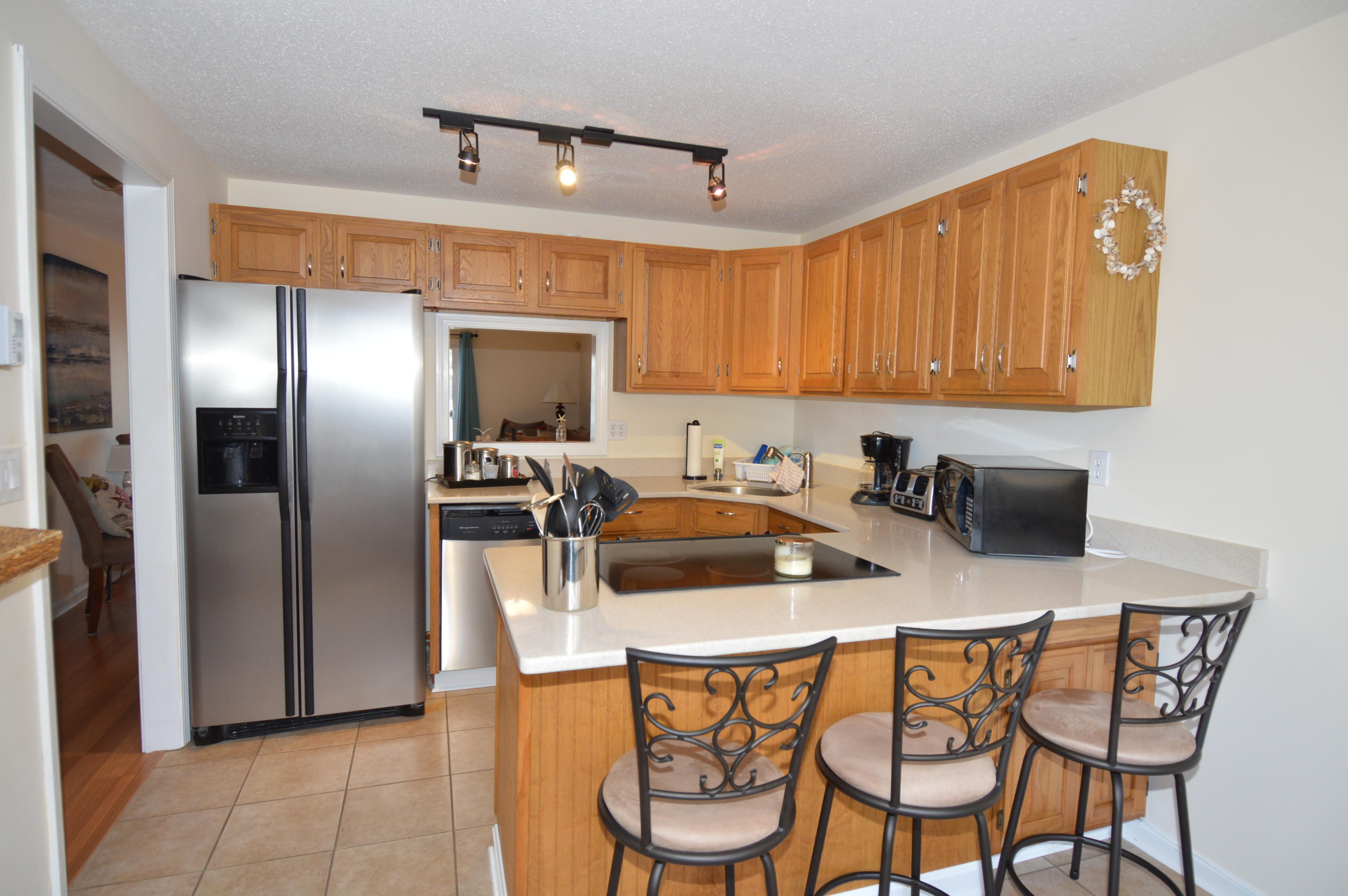174 Lowell Road, Unit T30 Mashpee, MA 02649 - Photo 6 of 19 a kitchen with stainless steel appliances a sink a table and chairs