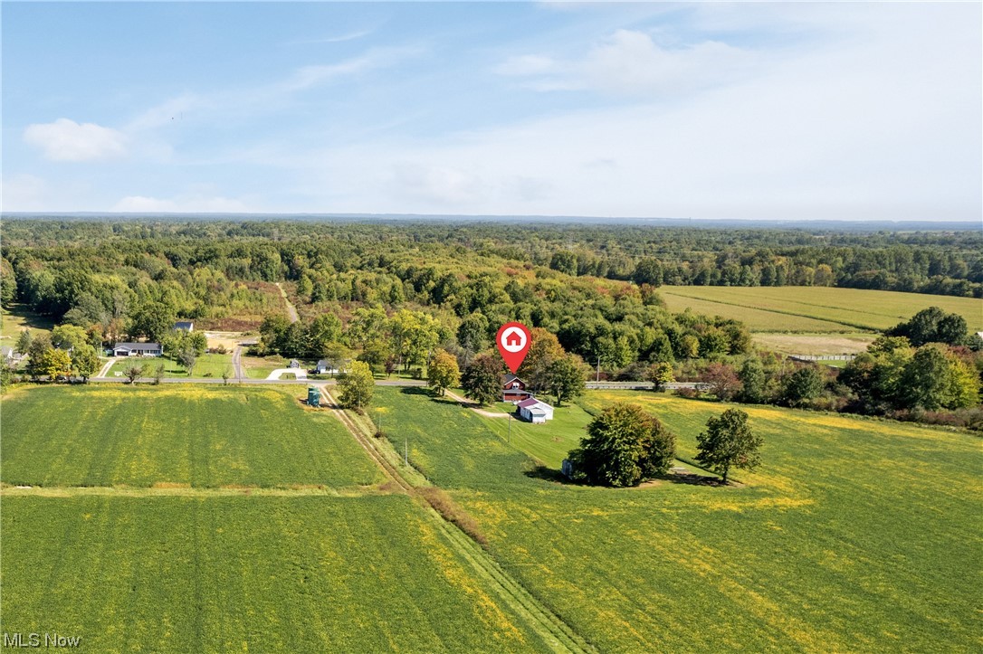 A view from the back of the land shows outbuildings as well as a farmhouse close to the road.