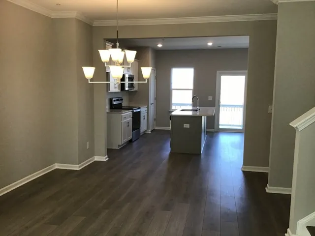 a kitchen with wooden floor and large windows