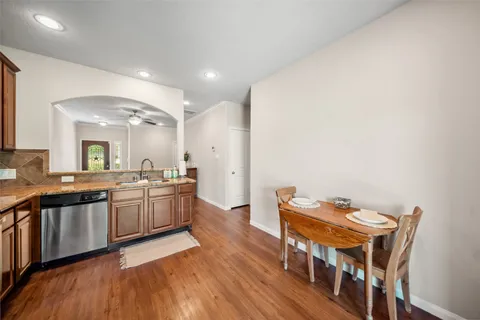 a kitchen with stainless steel appliances granite countertop a stove and a wooden floors