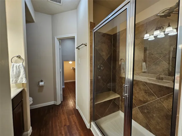a bathroom with a glass shower door and a mirror